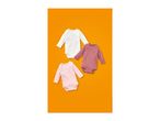 Three long-sleeved baby bodysuits in white, pink, and dark pink on an orange background.