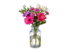 Gérberas, rosas e outras flores em um vaso.