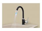 Black kitchen faucet with a blue LED light stream of water into a beige sink.