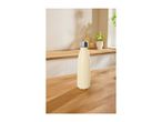 Cream-colored insulated stainless steel water bottle on a wooden kitchen table.