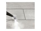 Steam cleaner cleaning grout lines between light grey floor tiles