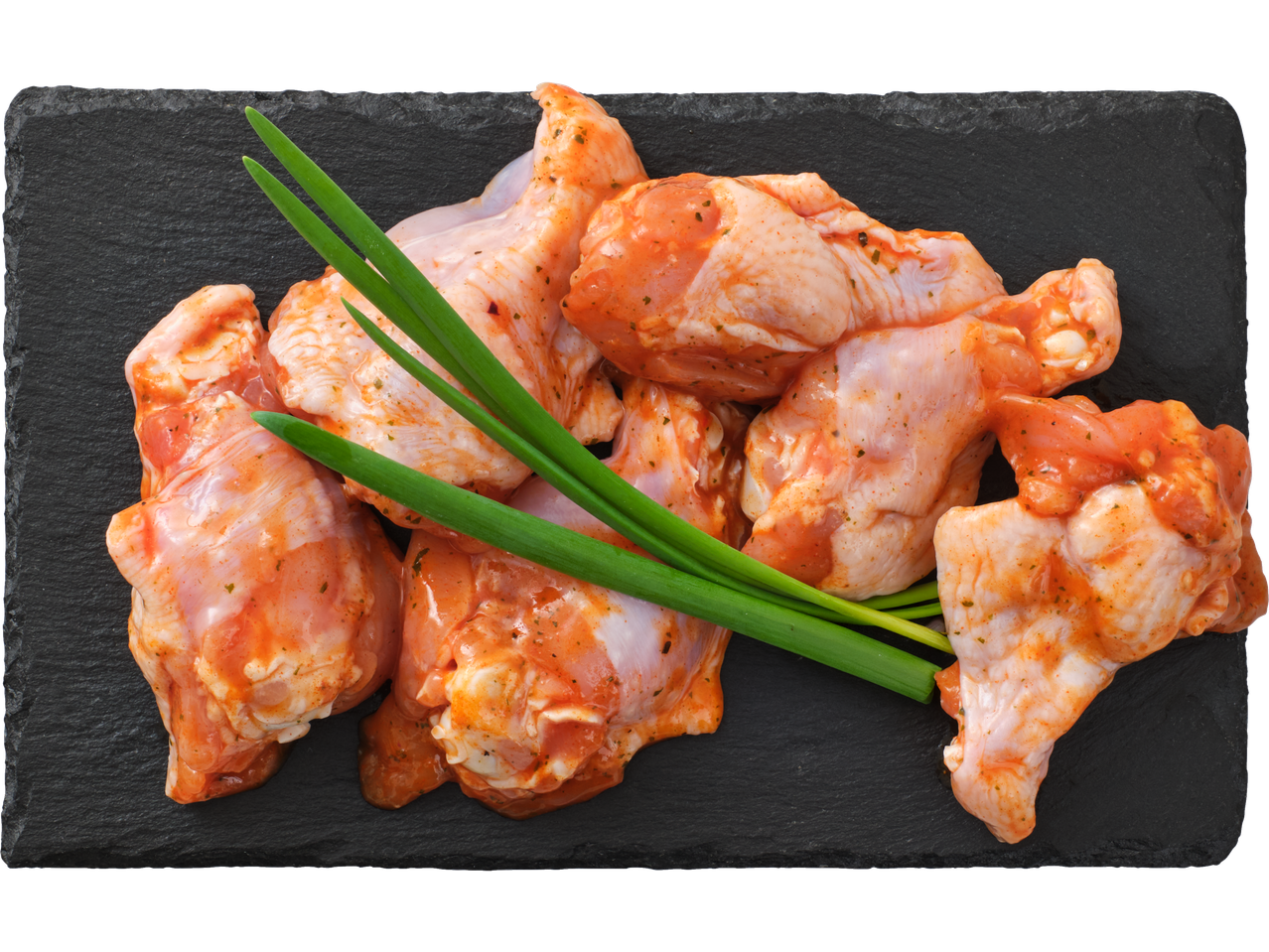 Marinēti vistas pusspārni ar lociņiem uz melna šīfera dēļa.