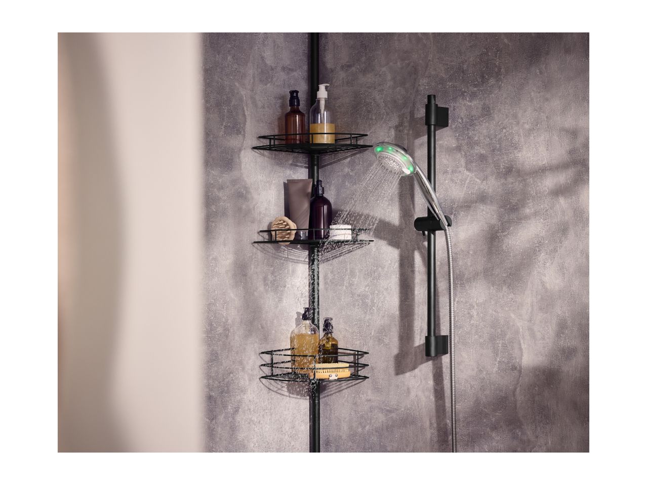 Shower caddy with bottles and a shower head with green lights in a modern bathroom.