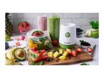 A blender with various fruits and vegetables, including strawberries, pineapple, watermelon, and spinach, ready for smoothies.