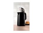 Black electric kettle with an open lid showing condensation, next to a stack of cookies.