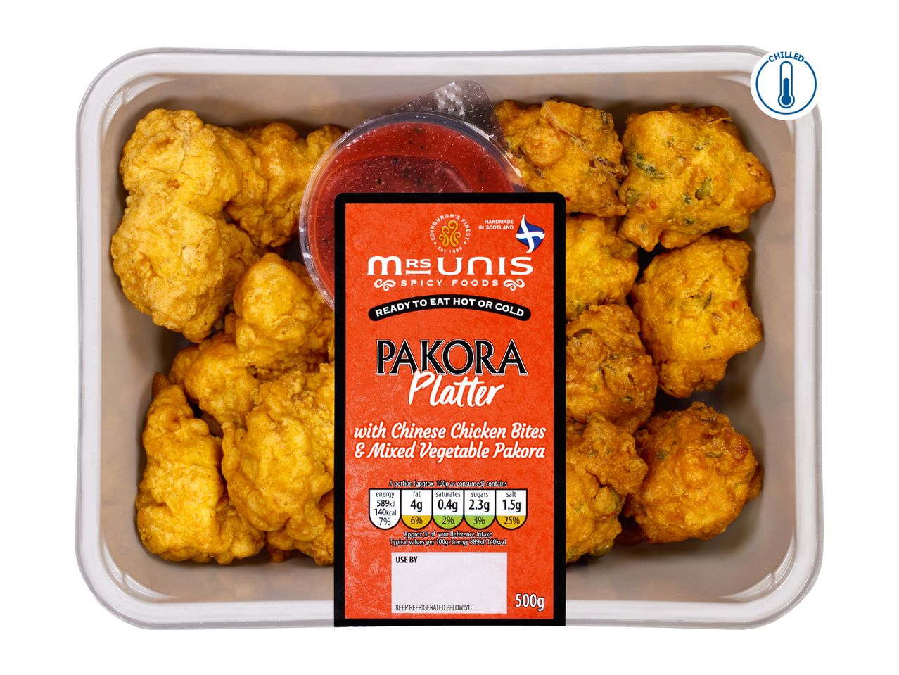 A platter of pakora with Chinese chicken bites and mixed vegetable pakora, with a dipping sauce.