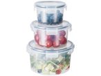 Three clear plastic food containers stacked, the top one filled with blueberries, the middle with cherry tomatoes, and the bottom with a salad.