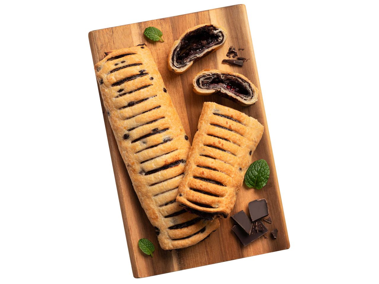 Két csokoládés-gyümölcsös péksütemény, egy egész és egy félbevágott, vágódeszkán.