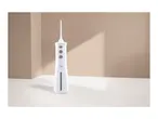 White cordless water flosser with multiple buttons and a transparent water tank on a light brown background.