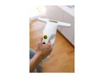 Hand holding a white handheld window vacuum cleaner with a green power button.