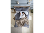 A woman sleeps soundly on a bed with a gray duvet and beige throw, using a body pillow.