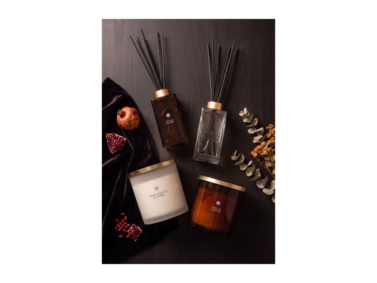 Elegant home fragrance set featuring reed diffusers and scented candles on a dark background.