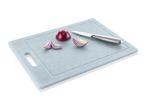 Light blue cutting board with a red onion, sliced onion pieces, and a small knife.