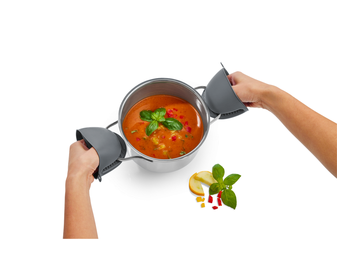 Sopa em uma panela, segurada por pegadores de silicone, servida com manjericão.