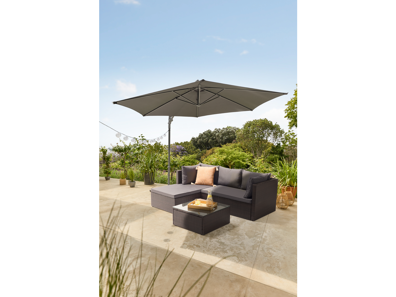 Guarda-sol cantilever LIVARNO com sofá de exterior e mesa de centro num pátio.