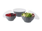 Three grey bowls with lids, two filled with berries and salad, on a white background.