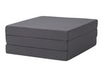 Foldable gray mattress, neatly stacked in three sections.