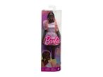 A Barbie doll in a pink dress is shown in its packaging, celebrating Barbie's 65th anniversary.
