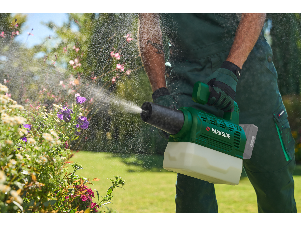 Bărbat udă flori cu un pulverizator de grădină fără fir.