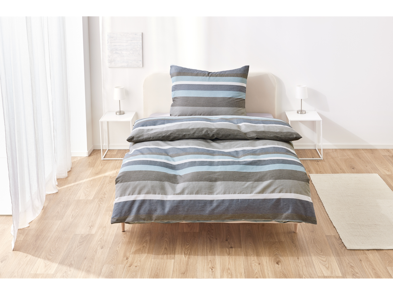 Striped bedding in blue and grey tones.