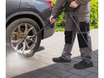 Homem a limpar a roda de um carro com uma lavadora de alta pressão PARKSIDE PERFORMANCE.