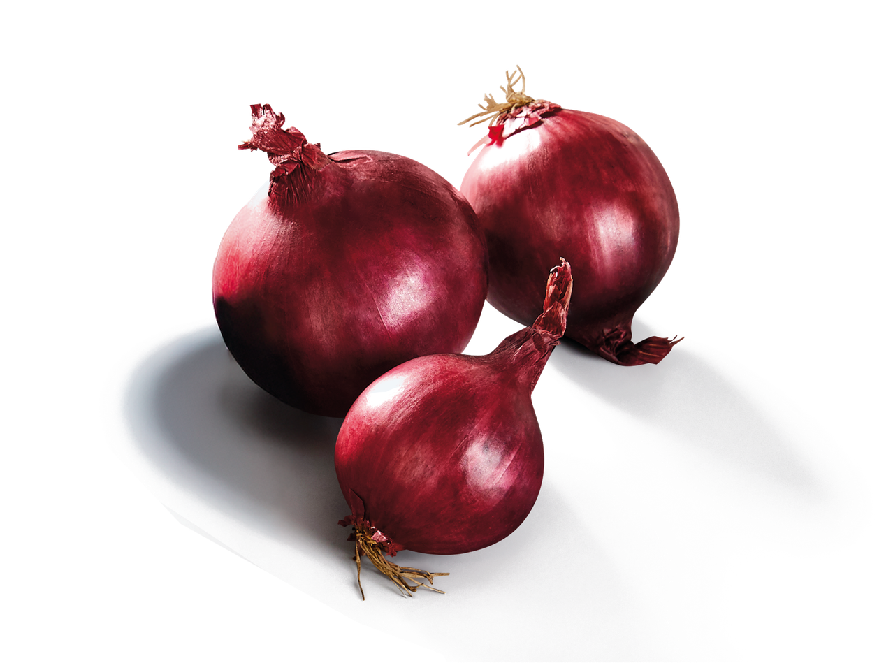 Trois oignons rouges entiers sur une surface blanche, fond noir.