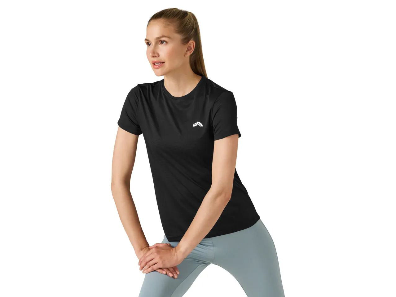 Woman in black short-sleeved sports top and light blue leggings stretching