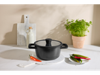 Panela de alumínio Silvercrest® sobre tábua de mármore com pimentas e salsa.