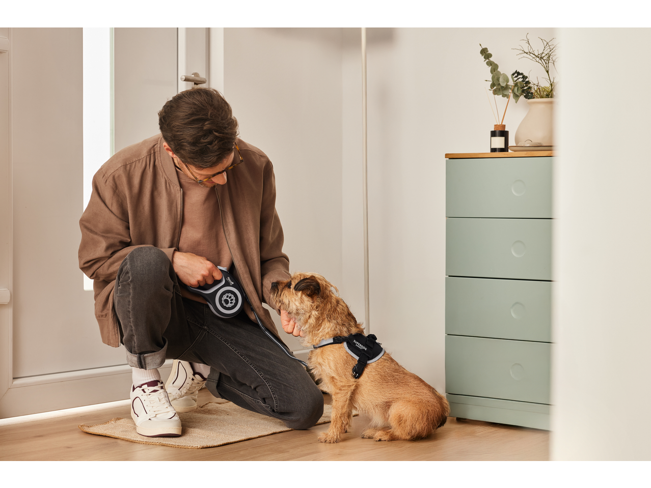 Man with Zoofari retractable dog lead and dog in a harness, ready for a walk.