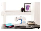 Singer M3205 sewing machine, fabrics and scissors.
