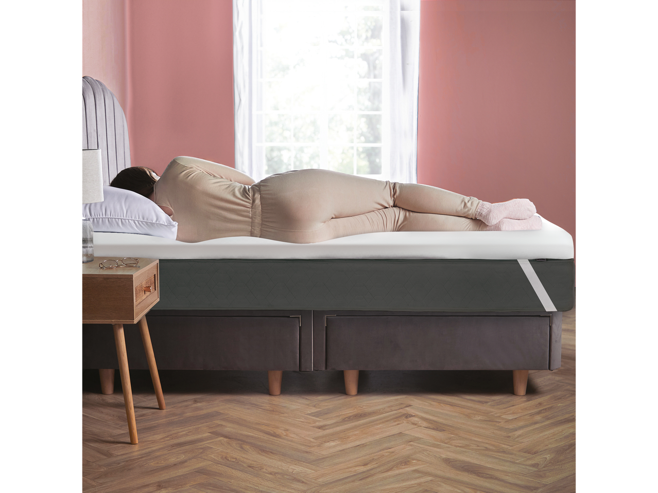 A person sleeping on a Silentnight Memory Foam Topper on a bed.