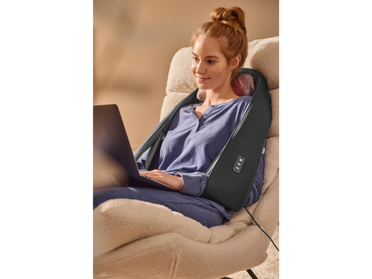Žena sa Sensiplast® šijacu masažnim jastukom i laptopom u fotelji