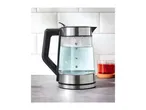 Glass and stainless steel kettle with water, next to a glass of red tea on a counter