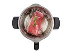 Raw steak with rosemary in a vacuum-sealed bag inside a sous vide cooker