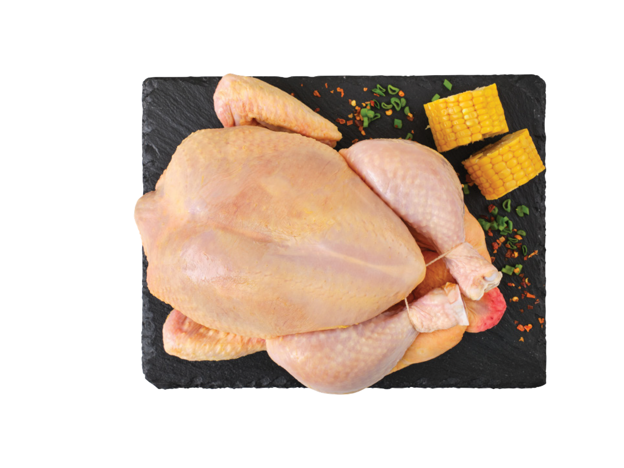 Jēla vesela vista uz melna dēlīša ar kukurūzu un garšvielām.