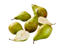 Green pears, some halved, against a black background.