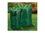 Two green garden waste bags filled with green leaves, standing on grass with trees in the background.