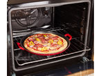 Assadeira de pizza de ferro fundido SILVERCREST no forno com pizza de salame, cebola e pimentão.