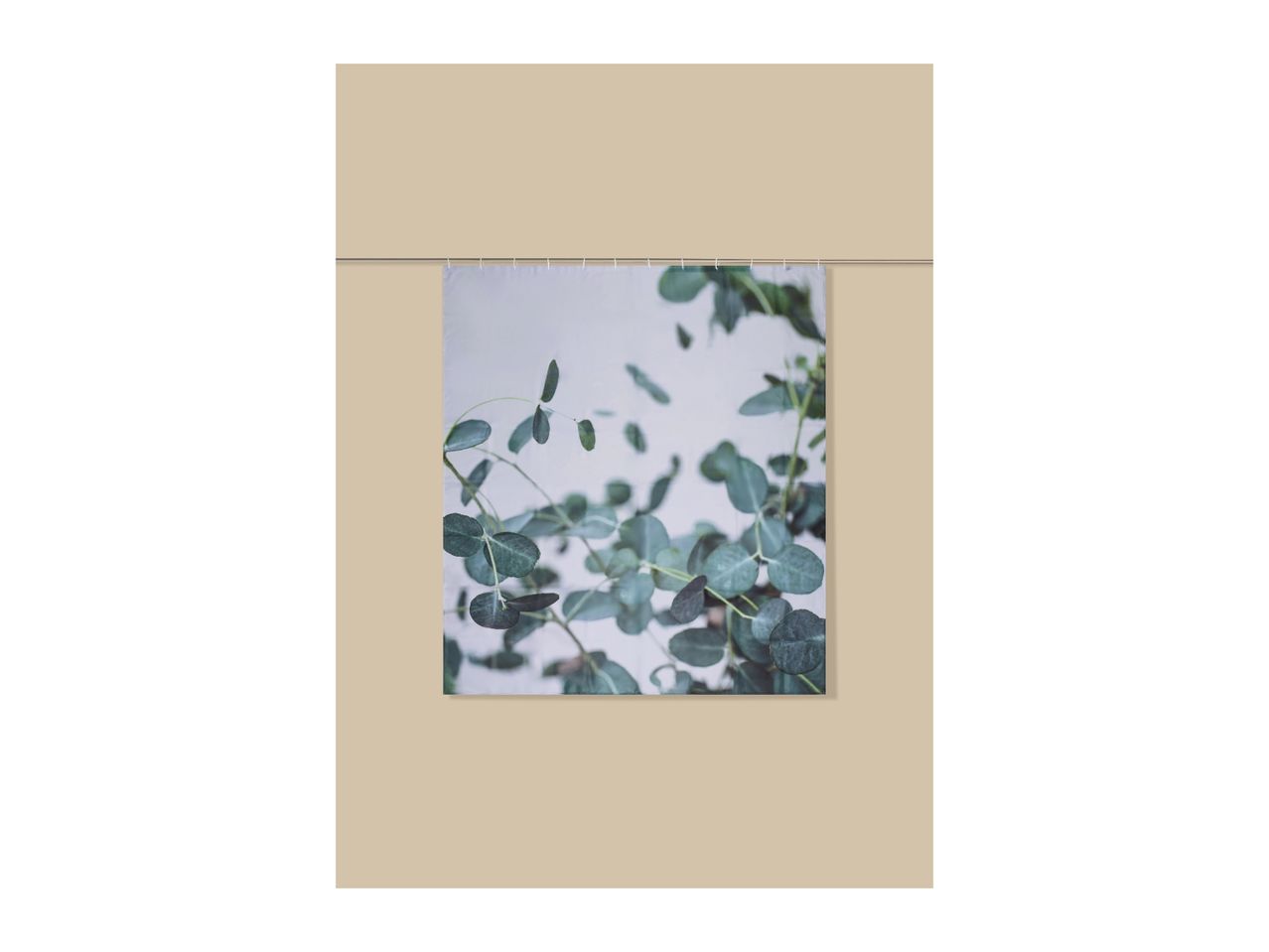 Shower curtain with a green eucalyptus leaf pattern, hanging on a rod.