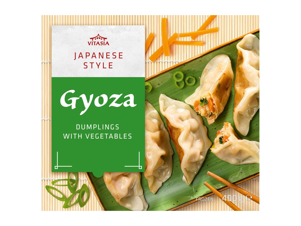 Japanese style gyoza dumplings with vegetables on a green plate with chopsticks.