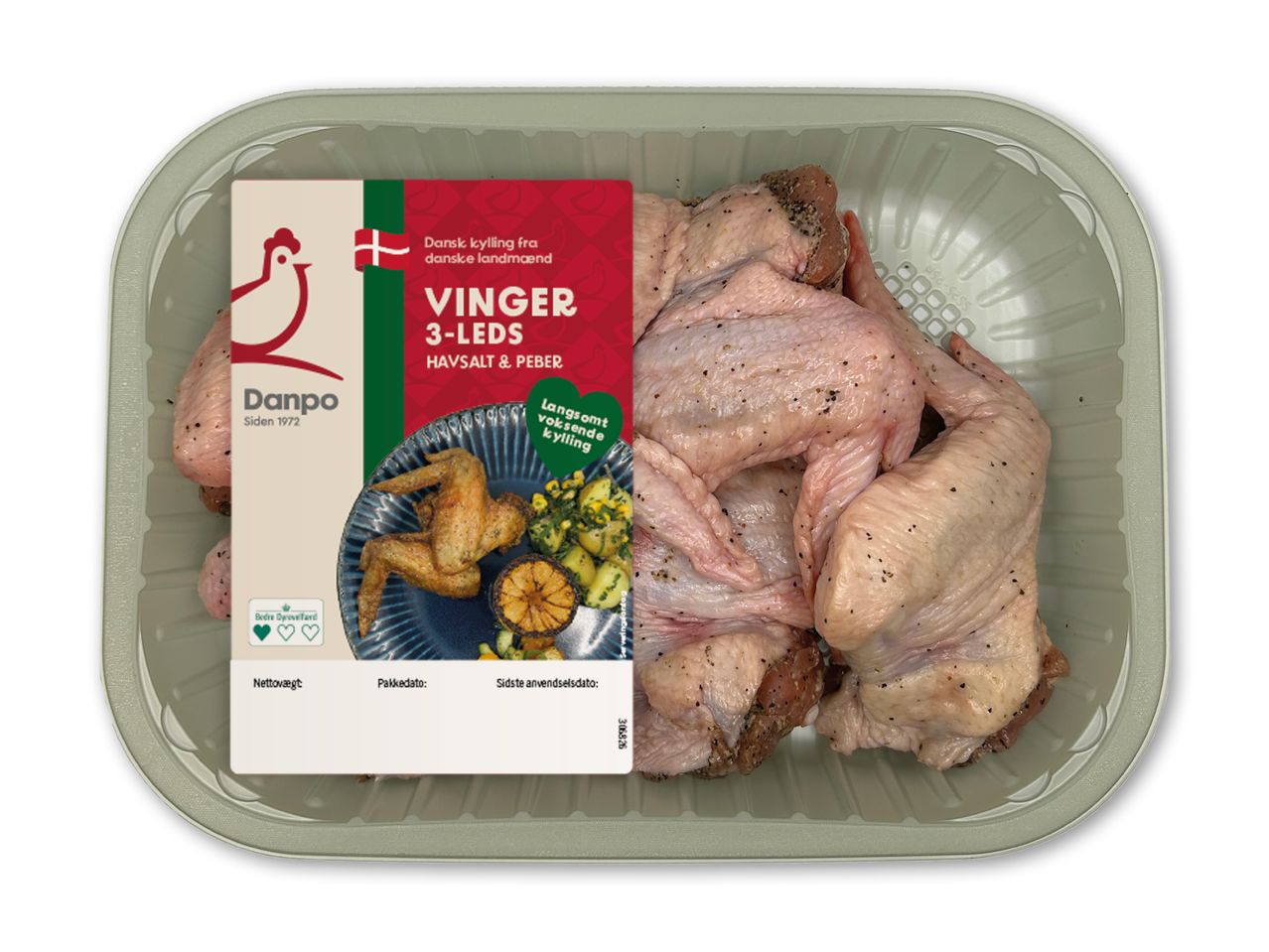 Rå kyllingevinger med havsalt og peber i bakke, med etiket der viser tilberedt ret.