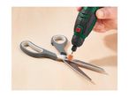 A person sharpening scissors with a rotary tool on a wooden surface.