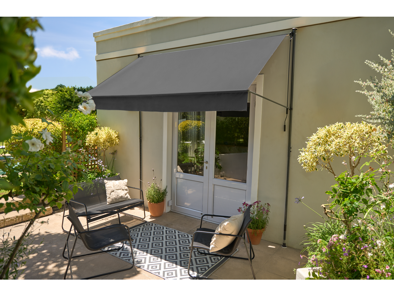 LIVARNO Klemmmarkise na terasi sa baštenskim nameštajem i biljkama.