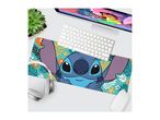 Stitch-themed desk mat with a computer, keyboard, mouse, headphones, and plant.