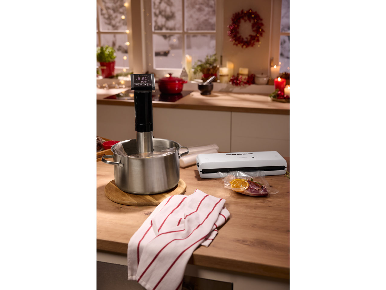 SILVERCREST® Vacuum Sealer and sous vide cooker with food in a festive kitchen.