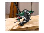 A Parkside miter saw cuts a piece of wood on a Holzmann workbench.