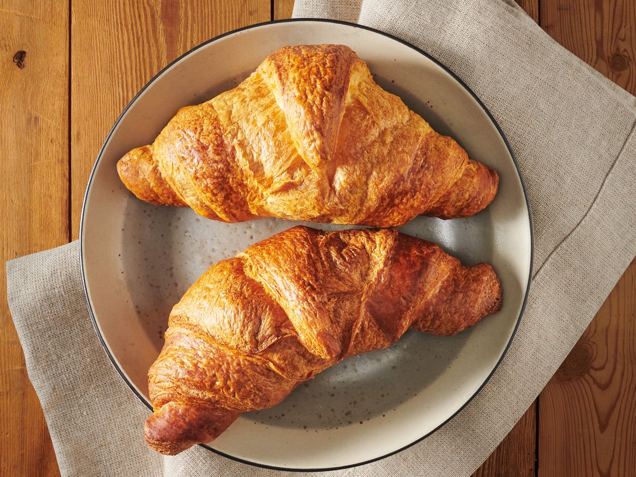 Две хрупкави кроасана в чиния.