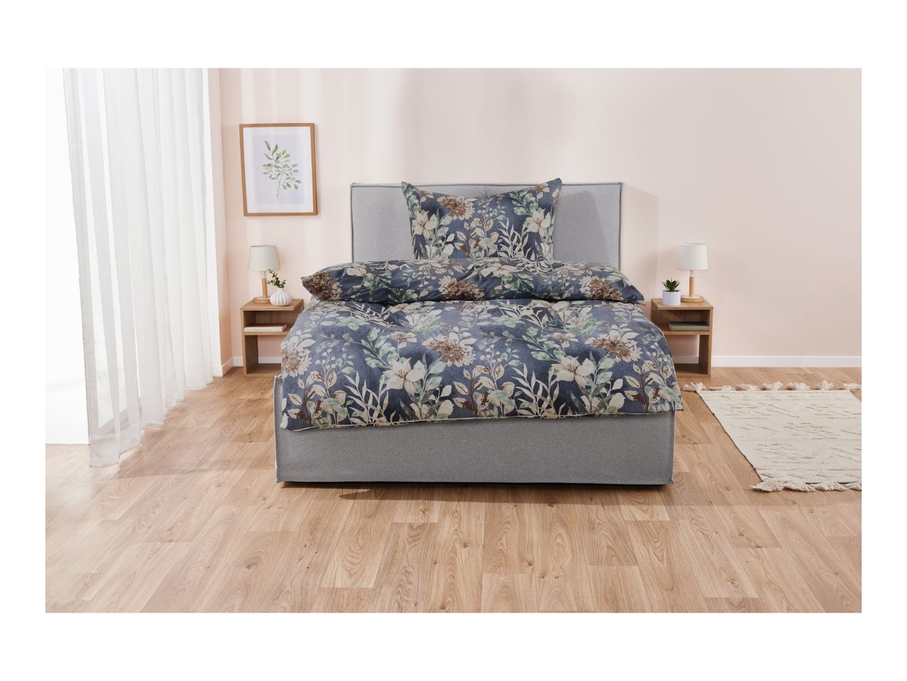 A bedroom with a bed featuring floral bedding, two nightstands, and a rug.