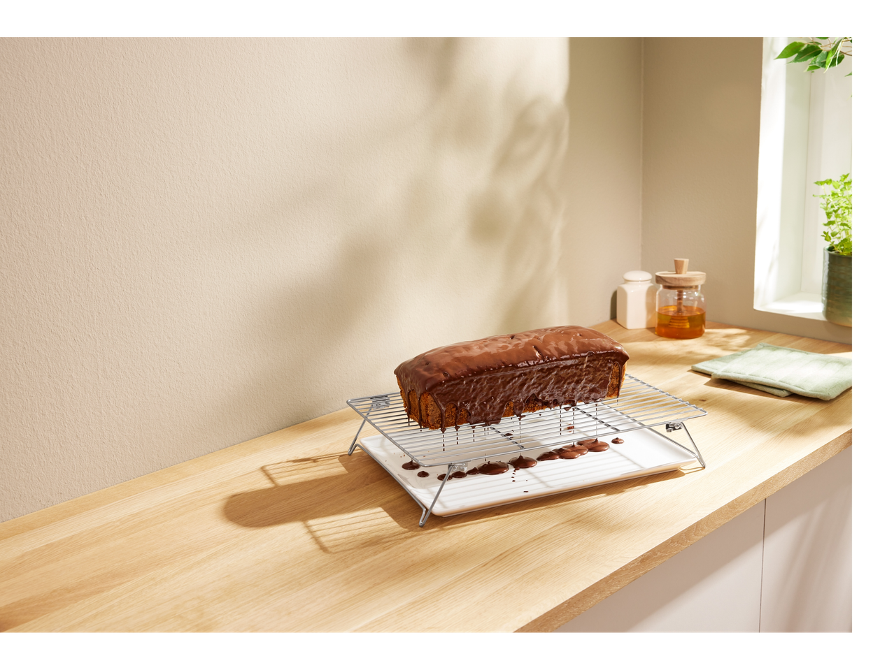Un tort de ciocolată pe un grătar de răcire într-o bucătărie modernă.