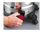 A person's hand unscrewing a red cap from a silver and black wet and dry vacuum cleaner.